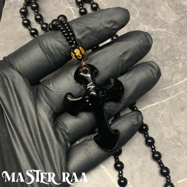 Black Onyx Cross Pendant Necklace held in hand – scale reference
