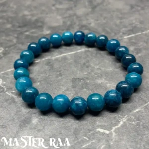 Apatite crystal bracelet with polished blue-green beads, laid flat on white background