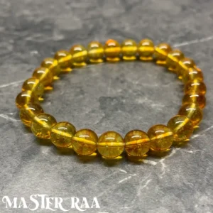 Citrine crystal bracelet with polished golden-yellow beads, laid flat on white background