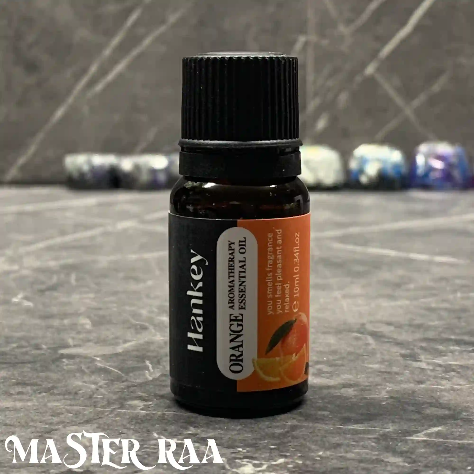 Orange essential oil bottle, 10ml, with citrus-themed label on grey background